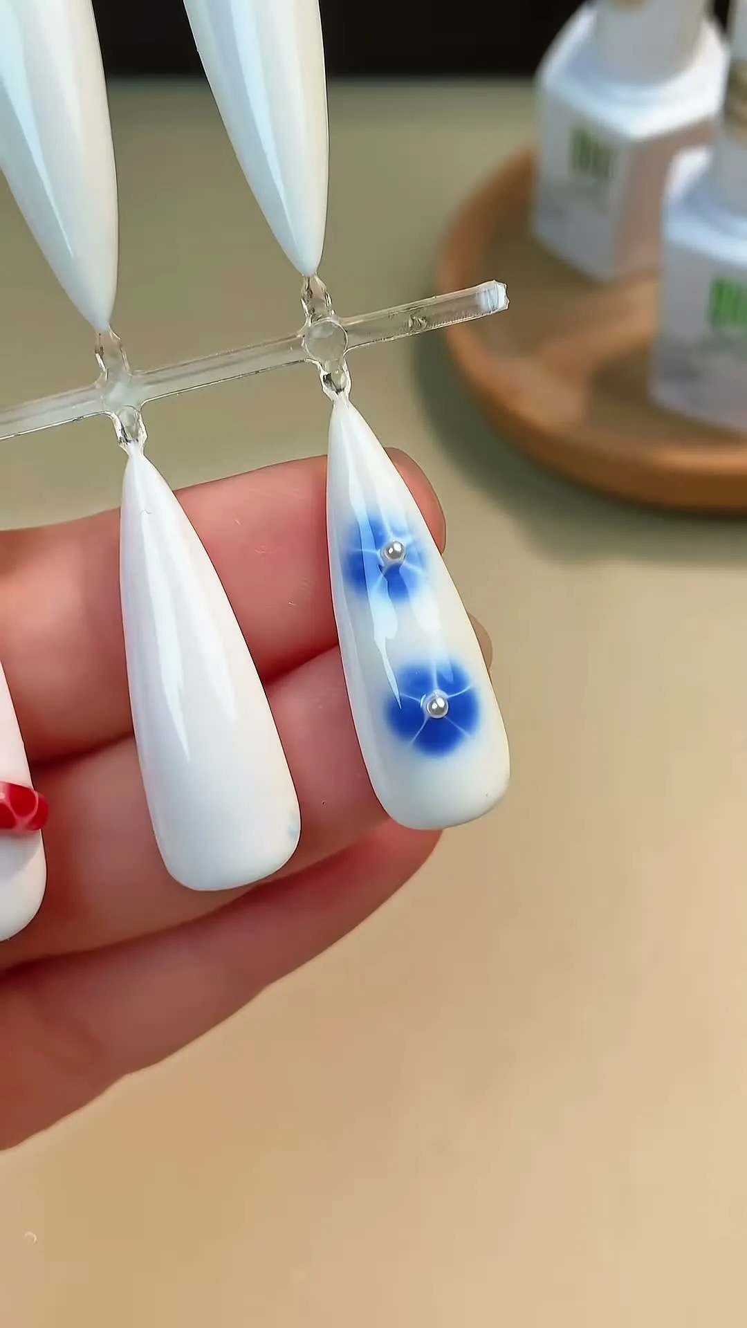 Sheer milky white nails with hand painted blue blooming gel flowers
